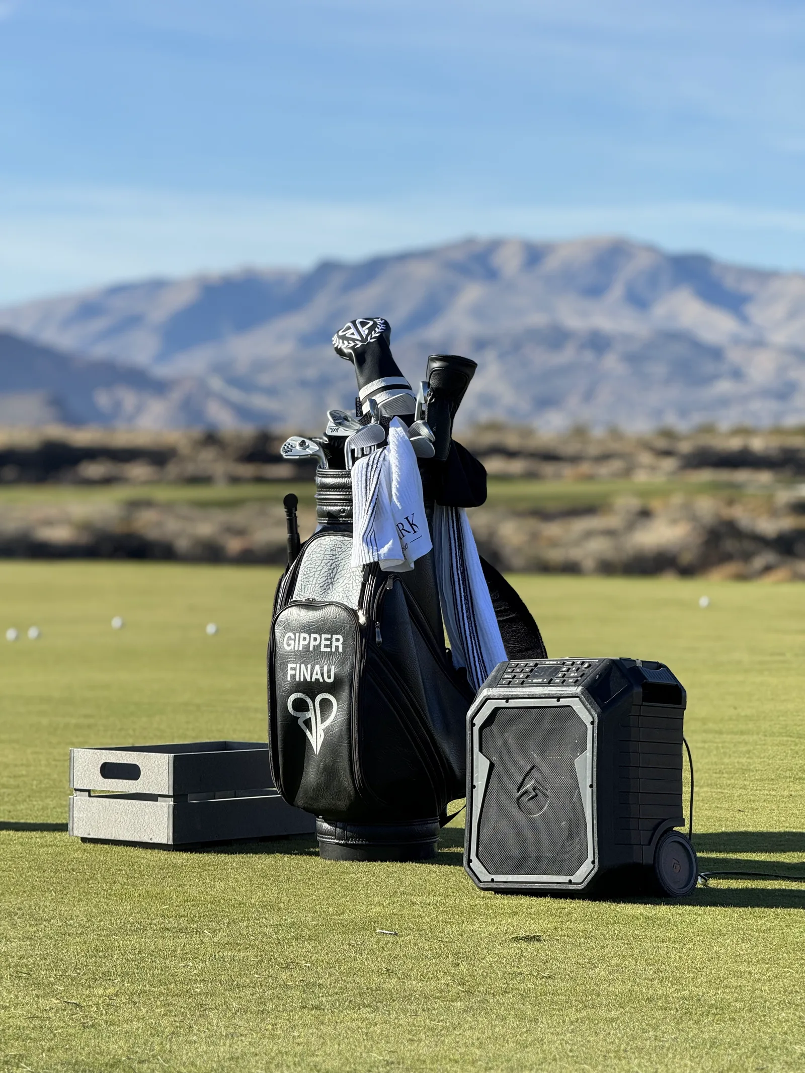 Gipper Finau golf bag and a portable speaker on a practice green